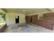 Wide angle of attached carport with brick and wood paneling, concrete flooring, and doors to the backyard at 4643 Wesley Dr, Austell, GA 30106
