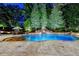 Night view of the serene backyard with a large pool, waterfall, and illuminated landscaping at 829 Big Horn Holw, Suwanee, GA 30024