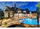 Evening shot of a luxurious backyard with a pool and spa, illuminated by landscape and home lighting at 829 Big Horn Holw, Suwanee, GA 30024