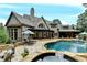 Elegant backyard with a pool, stone patio, and lush landscaping, perfect for outdoor entertaining at 829 Big Horn Holw, Suwanee, GA 30024