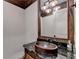 Charming bathroom with a marble countertop, rustic wooden mirror frame, and unique lighting fixture at 829 Big Horn Holw, Suwanee, GA 30024