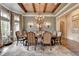 Elegant dining room with a chandelier, wood-beamed ceiling, and designer wallpaper at 829 Big Horn Holw, Suwanee, GA 30024