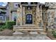 Grand stone entrance with an arched front door and meticulously crafted stonework at 829 Big Horn Holw, Suwanee, GA 30024