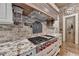 Close-up of a chef's kitchen featuring a professional-grade range and granite countertops at 829 Big Horn Holw, Suwanee, GA 30024