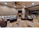 An outdoor living space with a stone fireplace, comfortable seating, TV, and a built-in grill at nighttime at 829 Big Horn Holw, Suwanee, GA 30024