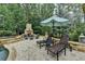 A luxurious outdoor patio with a stone fireplace, pool, lounge chairs and an umbrella at 829 Big Horn Holw, Suwanee, GA 30024