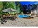 A luxurious outdoor patio with a stone pool, lounge chairs, an umbrella, and outdoor dining at 829 Big Horn Holw, Suwanee, GA 30024