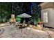 A luxurious outdoor patio with a stone fireplace, pool, lounge chairs and an umbrella at nighttime at 829 Big Horn Holw, Suwanee, GA 30024