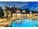 Night view of luxury backyard pool with a covered outdoor living space and ample lounge seating at 829 Big Horn Holw, Suwanee, GA 30024