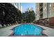 Outdoor swimming pool surrounded by lounge chairs, lush greenery and tall buildings in the background at 1101 Juniper Ne St # 1504, Atlanta, GA 30309