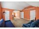 Open and bright bedroom featuring multiple doors, a large area rug, and vibrant orange walls at 1644 Cutters Mill Dr, Lithonia, GA 30058