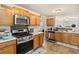 Well-lit kitchen featuring wood cabinets, stainless steel appliances, and granite countertops at 1644 Cutters Mill Dr, Lithonia, GA 30058