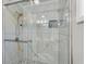 Beautifully tiled glass enclosed shower with a sleek shower head, bench, and patterned tile at 360 W Spalding Dr, Atlanta, GA 30328