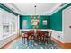 Formal dining room with wainscoting, hardwood floors, a chandelier, and a patterned rug at 3810 Branch Bluff Ln, Cumming, GA 30040