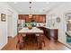 Well-lit kitchen featuring stainless steel appliances, center island, wood cabinets, and backyard views at 3810 Branch Bluff Ln, Cumming, GA 30040