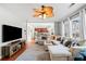Open-concept living room showcasing hardwood floors, a ceiling fan, and easy access to the kitchen at 3810 Branch Bluff Ln, Cumming, GA 30040