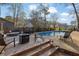 Backyard deck with swimming pool in background with outdoor seating, fire pit and dining area at 4570 Nantucket Sw Dr, Lilburn, GA 30047