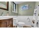 Charming powder room with white wainscoting, sage walls and vanity with dark wood finish at 4570 Nantucket Sw Dr, Lilburn, GA 30047