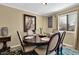 Sunlit dining room features a round wood table, six upholstered chairs and a peacock painting at 4570 Nantucket Sw Dr, Lilburn, GA 30047