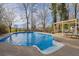 Backyard pool with a sunbathing ledge, and a lounge area, perfect for relaxation and outdoor entertaining at 4570 Nantucket Sw Dr, Lilburn, GA 30047