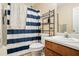 Bathroom with a striped shower curtain, toilet, sink, and metal shelving unit at 60 Cypress Dr, Covington, GA 30016