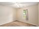 Bedroom with neutral walls and a window overlooking a tree filled yard at 60 Cypress Dr, Covington, GA 30016
