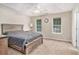Spacious main bedroom featuring a tray ceiling, plush carpeting, and large windows providing natural light at 60 Cypress Dr, Covington, GA 30016