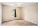 Bedroom with neutral walls, carpet flooring, and a view of a tree filled front yard at 60 Cypress Dr, Covington, GA 30016