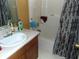 Cozy bathroom featuring a single sink, white cabinets, and a shower-tub combo with patterned curtain at 1662 Maple Trace Ct, Grayson, GA 30017