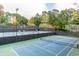 A view of well maintained tennis courts with dark fencing and lighting at 2664 Stonebrook Ne Ct, Roswell, GA 30075