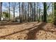 Expansive backyard surrounded by mature trees, offering privacy and natural beauty at 6710 Hidden Brook Trl, Atlanta, GA 30349