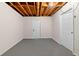 Unfinished basement with gray painted flooring and exposed ceiling with utility access at 6710 Hidden Brook Trl, Atlanta, GA 30349