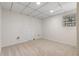 Unfinished carpeted basement room featuring a small window and utility closet at 6710 Hidden Brook Trl, Atlanta, GA 30349