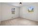Empty bedroom with neutral carpet, light walls, and two windows providing ample natural light at 6710 Hidden Brook Trl, Atlanta, GA 30349