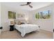 Bright bedroom featuring natural light, neutral walls, a ceiling fan, and two bedside lamps at 6710 Hidden Brook Trl, Atlanta, GA 30349