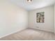 Empty bedroom featuring carpet flooring, neutral walls, and natural light from a single window at 6710 Hidden Brook Trl, Atlanta, GA 30349