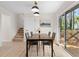 Cozy dining area with wood table, modern chairs, large sliding glass door, and staircase nearby at 6710 Hidden Brook Trl, Atlanta, GA 30349
