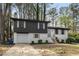 Charming two-story home with black and white painted brick, attached garage, and landscaped yard at 6710 Hidden Brook Trl, Atlanta, GA 30349