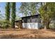 Back exterior of home featuring a patio area with backyard access surrounded by mature trees at 6710 Hidden Brook Trl, Atlanta, GA 30349