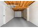 Unfinished basement garage featuring gray flooring, exposed utilities, and a large garage door at 6710 Hidden Brook Trl, Atlanta, GA 30349