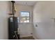 Functional laundry room featuring a water heater with a window to the exterior at 2297 Hylaea Rd, Tucker, GA 30084