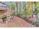 Backyard featuring a staircase, stream, and wooded surroundings at 1667 Manhasset Farm Ct, Atlanta, GA 30338