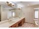 Bathroom featuring double sinks, wooden cabinets, and a large mirror at 1667 Manhasset Farm Ct, Atlanta, GA 30338
