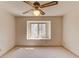 Bright, neutral carpeted bedroom featuring a ceiling fan and large window at 1667 Manhasset Farm Ct, Atlanta, GA 30338