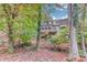 View of the exterior of a multi-level home with a wooden deck and wooded surroundings at 1667 Manhasset Farm Ct, Atlanta, GA 30338