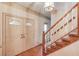 Foyer view showcasing the front door, hardwood floors, and the staircase leading to the upper level at 1667 Manhasset Farm Ct, Atlanta, GA 30338
