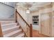 Foyer featuring a staircase, hardwood floors, and a glimpse into the living room with a stone fireplace at 1667 Manhasset Farm Ct, Atlanta, GA 30338