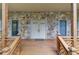 Inviting covered front porch featuring stone accents and a warm wood railing, leading to the front door at 1667 Manhasset Farm Ct, Atlanta, GA 30338