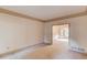 Spacious living room with plush carpeting and a doorway that opens into the dining room at 1667 Manhasset Farm Ct, Atlanta, GA 30338