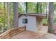 Image shows a shed exterior with a deck area nestled among mature trees at 1667 Manhasset Farm Ct, Atlanta, GA 30338